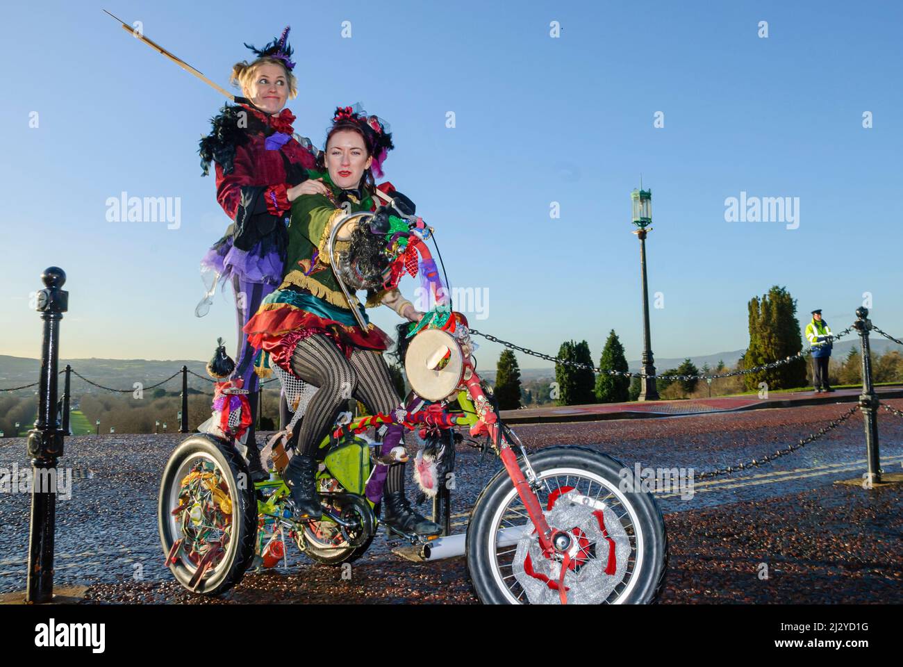 Belfast, Irlanda del Nord, 10th dicembre 2007. Madre e figlia strada che esegue il duo circus, la carosello arida, cavalcare un triciclo a una protesta contro i tagli d'arte. Foto Stock