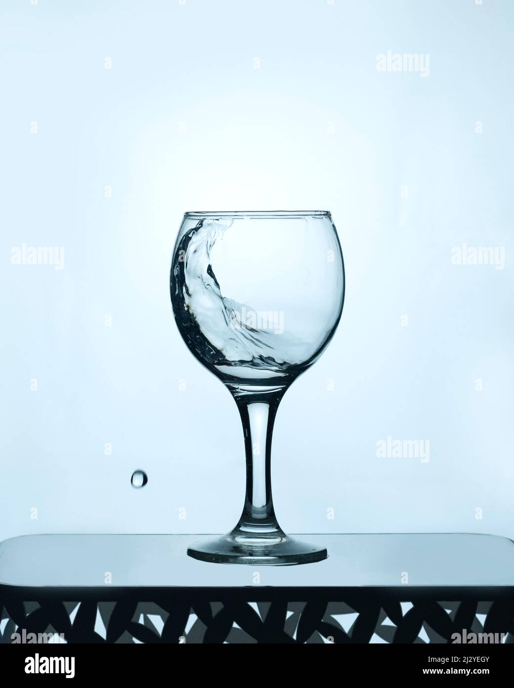 bicchiere d'acqua pulita con uno spruzzo su sfondo chiaro Foto Stock