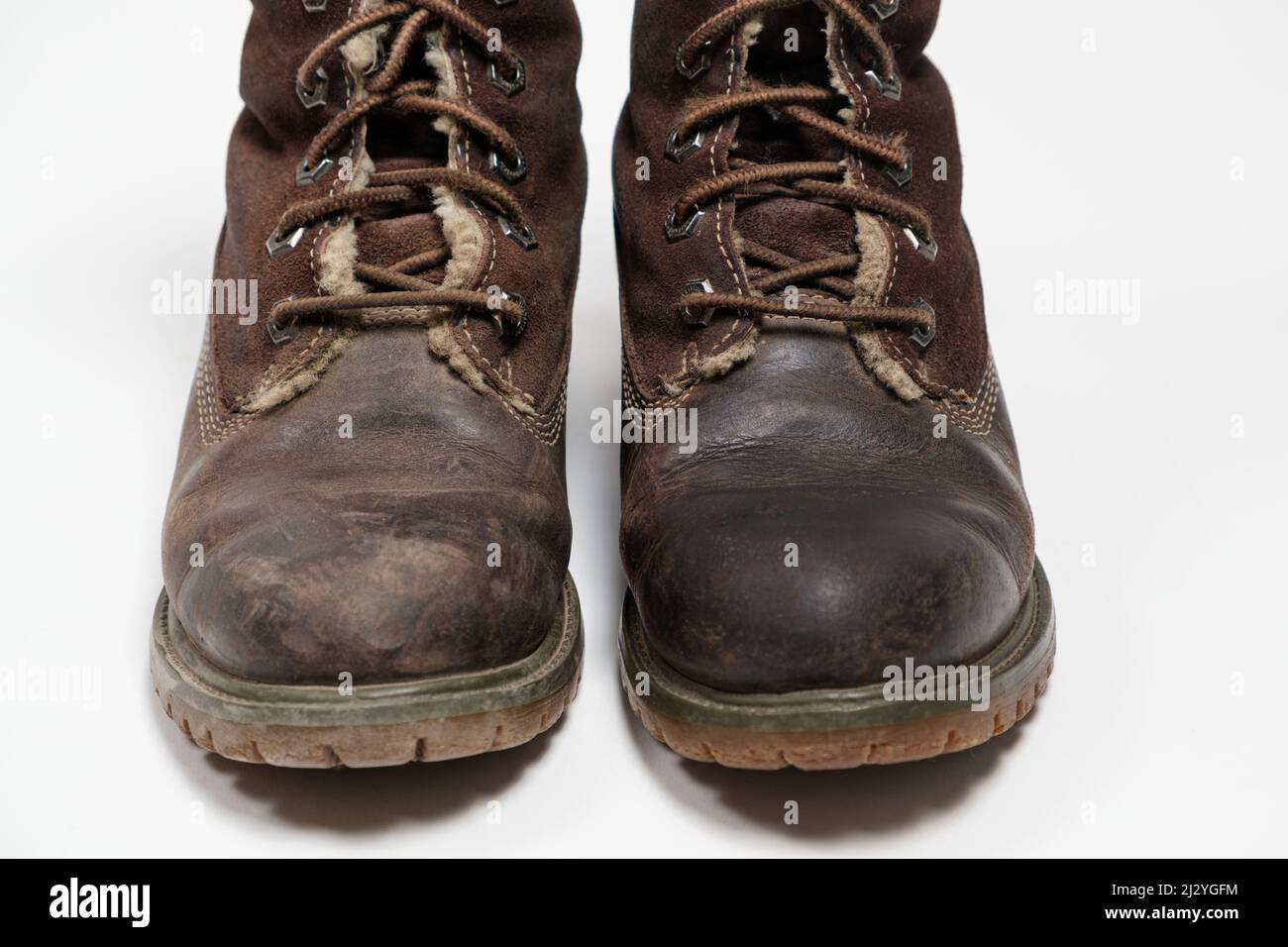 Stivali nubuck marroni - uno sporco, il secondo pulito su sfondo bianco. Cura delle scarpe. Foto Stock