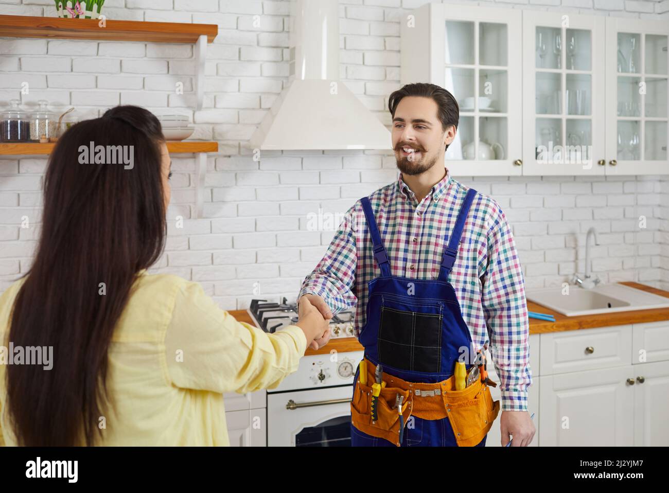 Maschio idraulico handshake soddisfatto femmina cliente Foto Stock