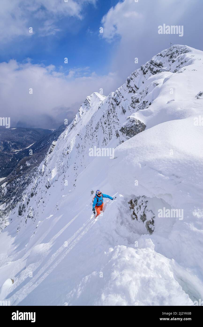 La donna in giro per lo sci sale fino a Hinteres Sonnwendjoch, Hinteres Sonnwendjoch, Alpi bavaresi, Tirolo, Austria Foto Stock