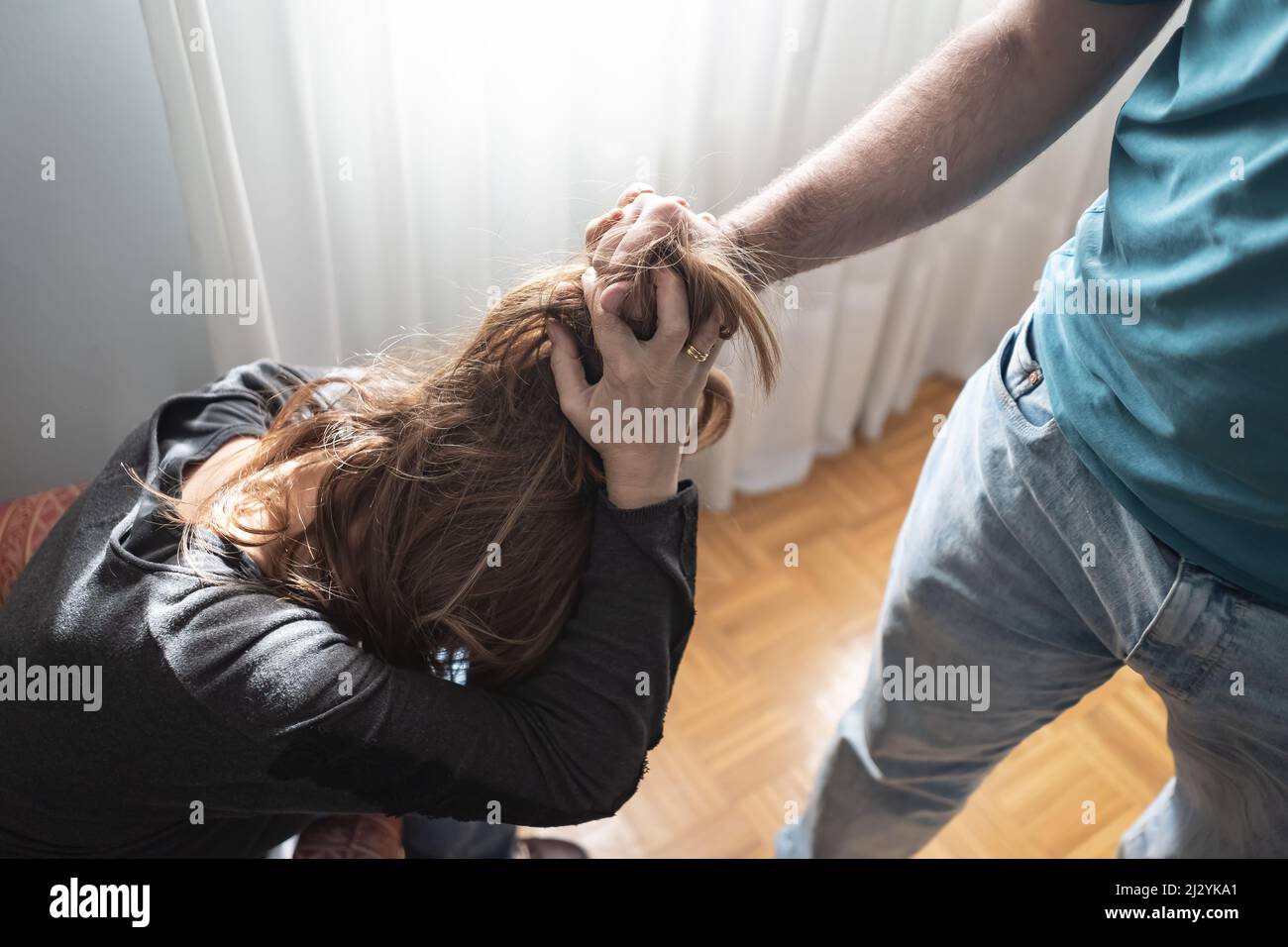 Uomo abusato tirando i capelli della moglie mentre si difende dall'aggressione. Foto Stock