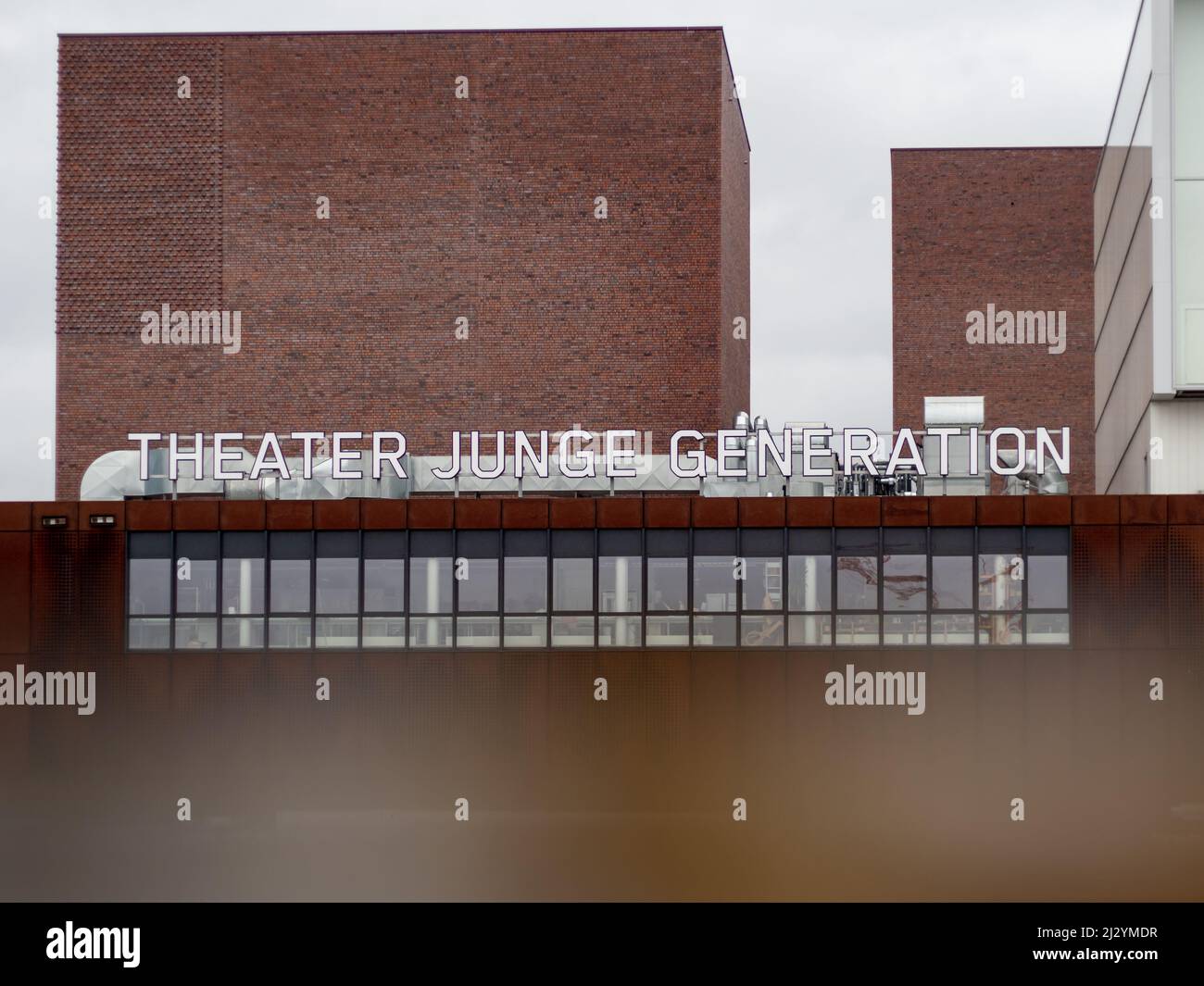 Teatro Junge Generation scritta su un vecchio edificio industriale. Il teatro produce cultura per un pubblico giovane. La facciata è in acciaio arrugginito. Foto Stock