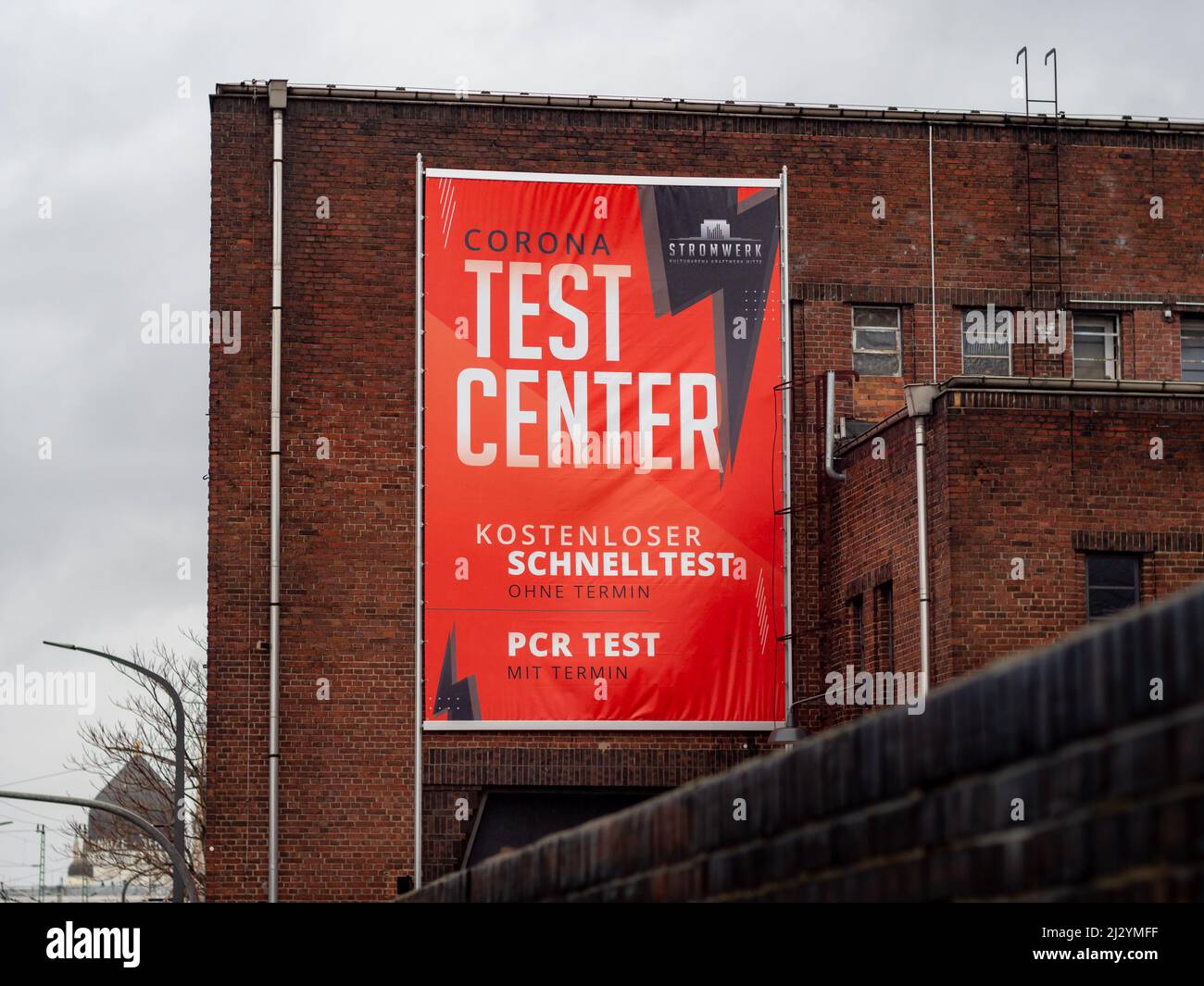 Centro di test Covid-19 per eseguire un test dell'antigene e un test PCR in una precedente sede di eventi nella città. Banner pubblicitario sulla facciata di un edificio. Foto Stock