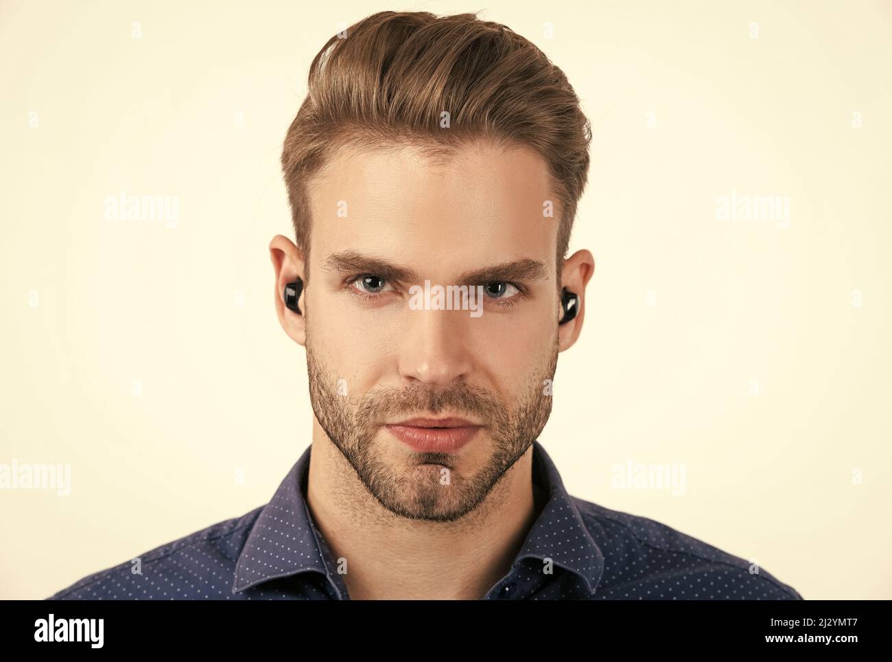 bell'uomo senza rasature con auricolari bluetooth wireless isolati su cuffie bluetooth bianche Foto Stock
