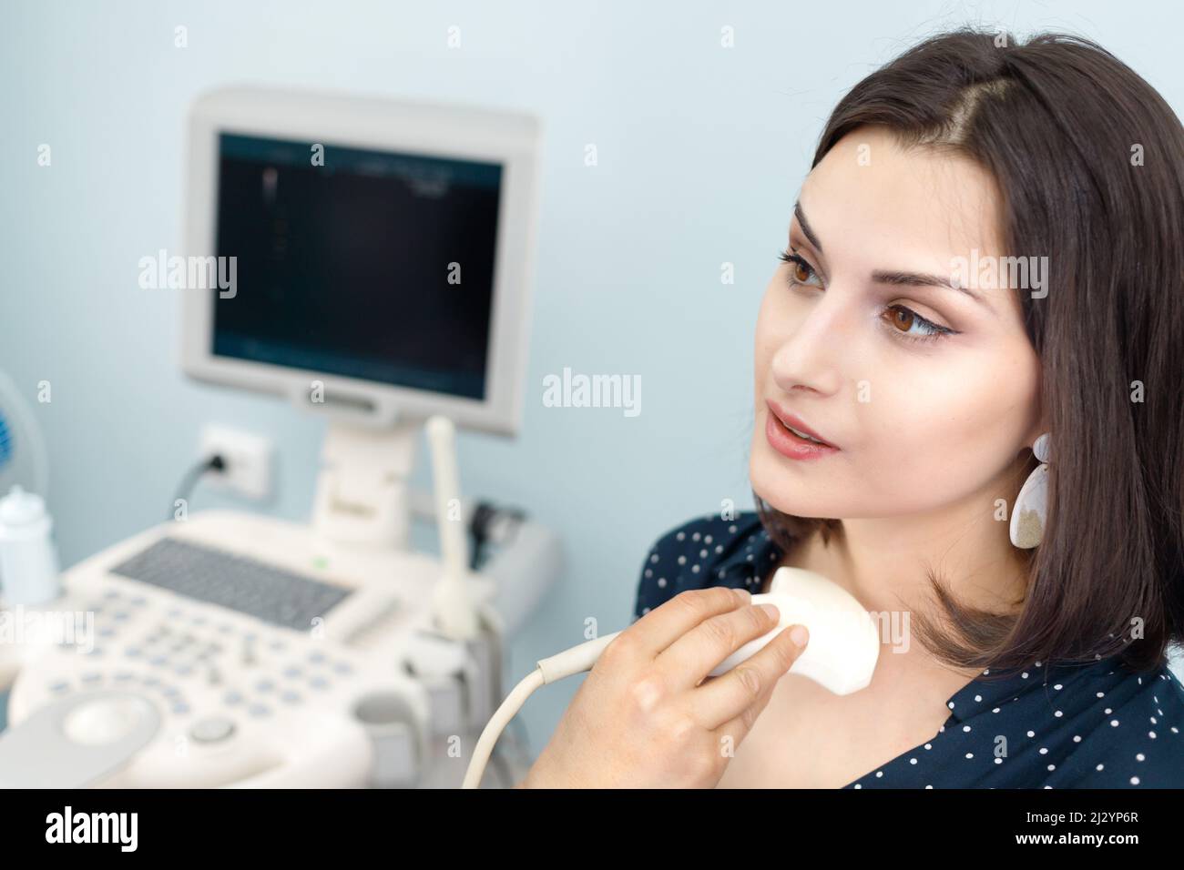 Tecnico che effettua la diagnosi di pazienti di sesso femminile utilizzando un moderno scanner a ultrasuoni nel centro diagnostico. Foto Stock