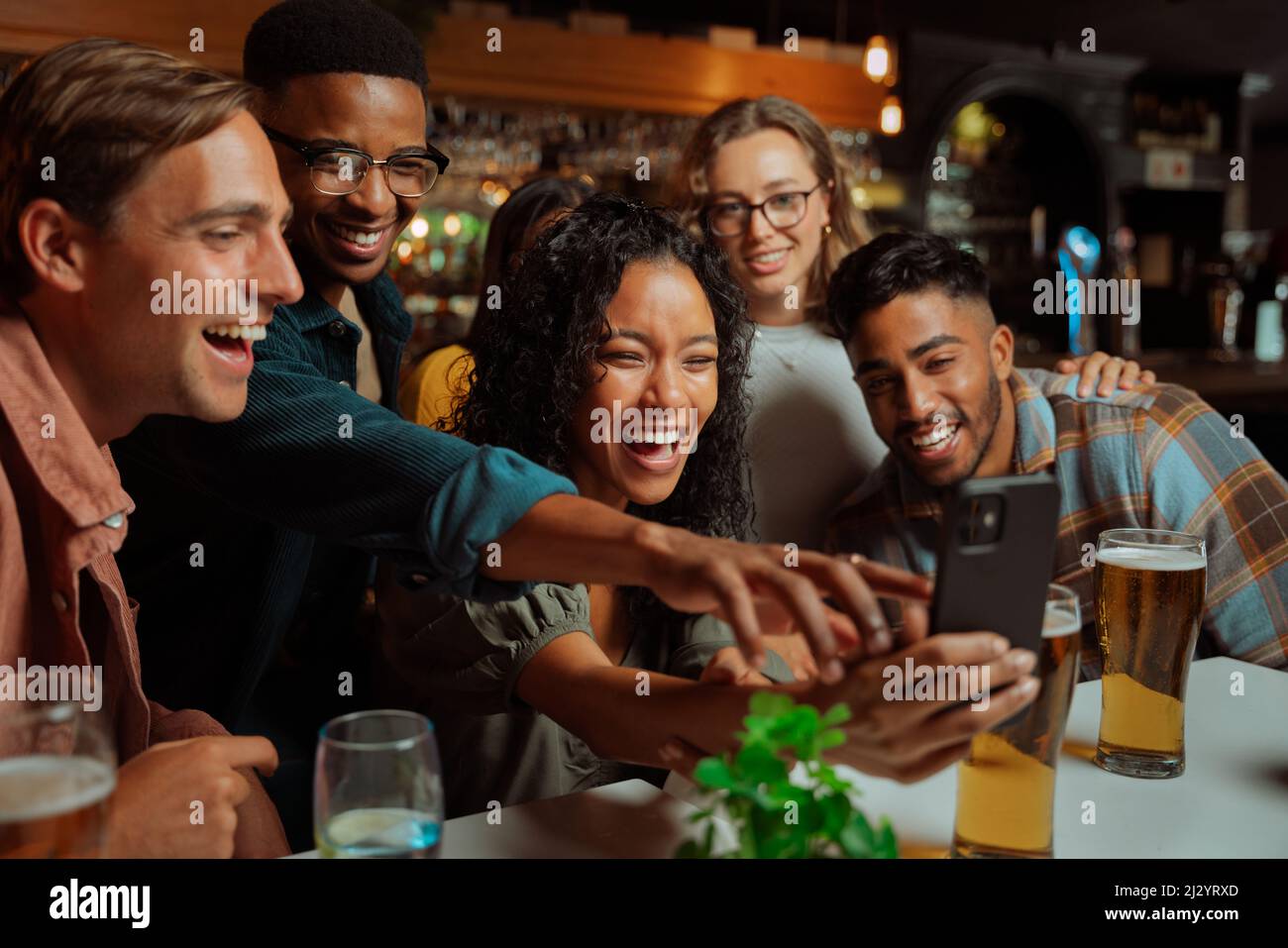 Gruppo di giovani amici adulti che prendono selfie a cena seduti al ristorante Foto Stock