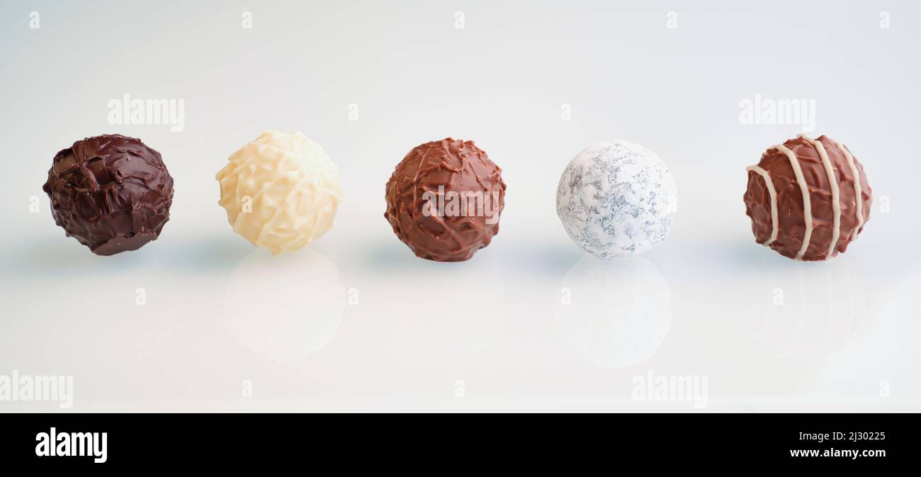 fila di cinque tartufi di cioccolato su sfondo bianco con riflessi, dimensione banner Foto Stock