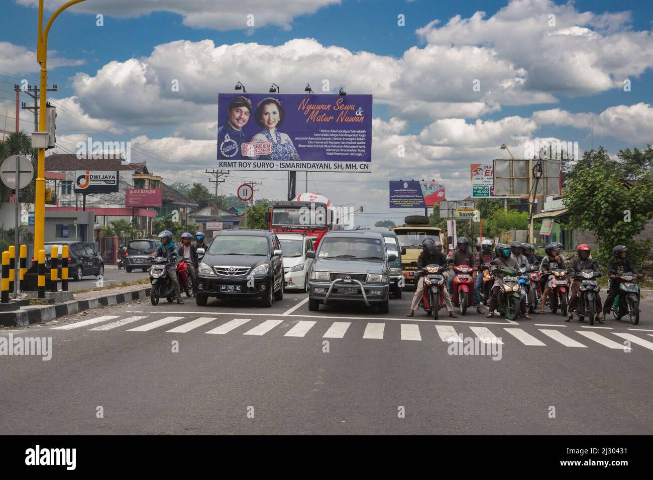 Yogyakarta, Java, Indonesia. Motocicli e automobili a intersezione, in attesa di luce al cambiamento. Foto Stock