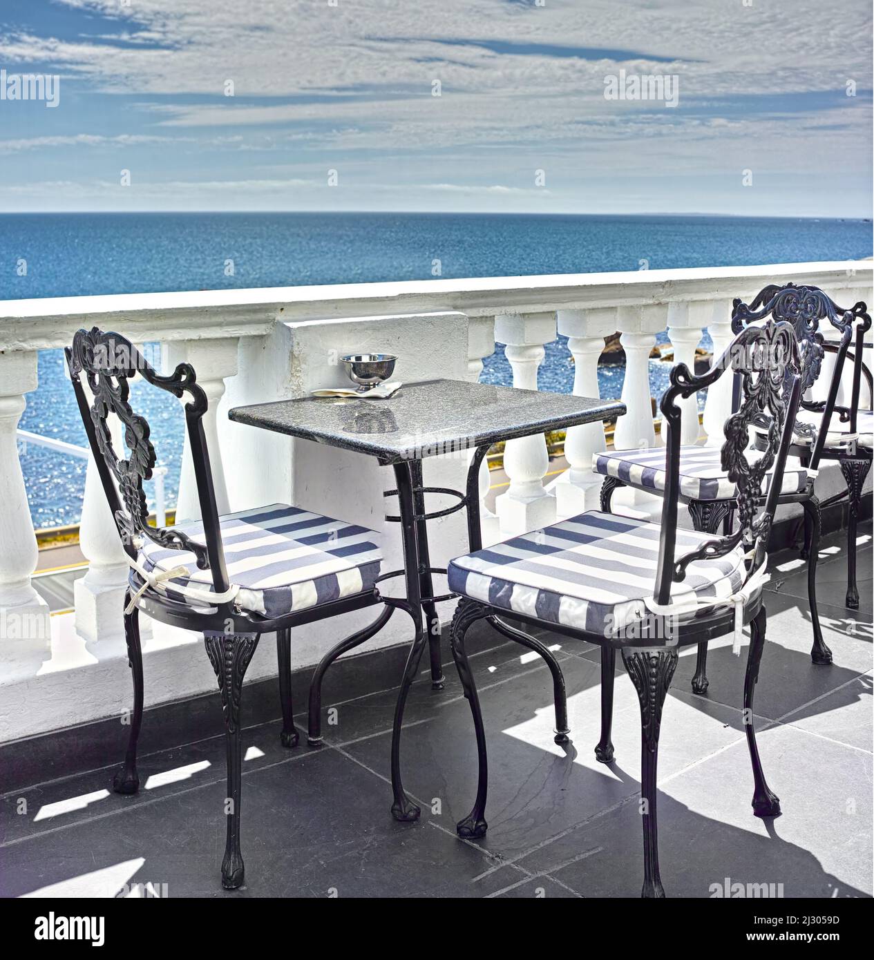 Che punto di vista. Tavoli e sedie sul balcone di un ristorante sul mare. Foto Stock