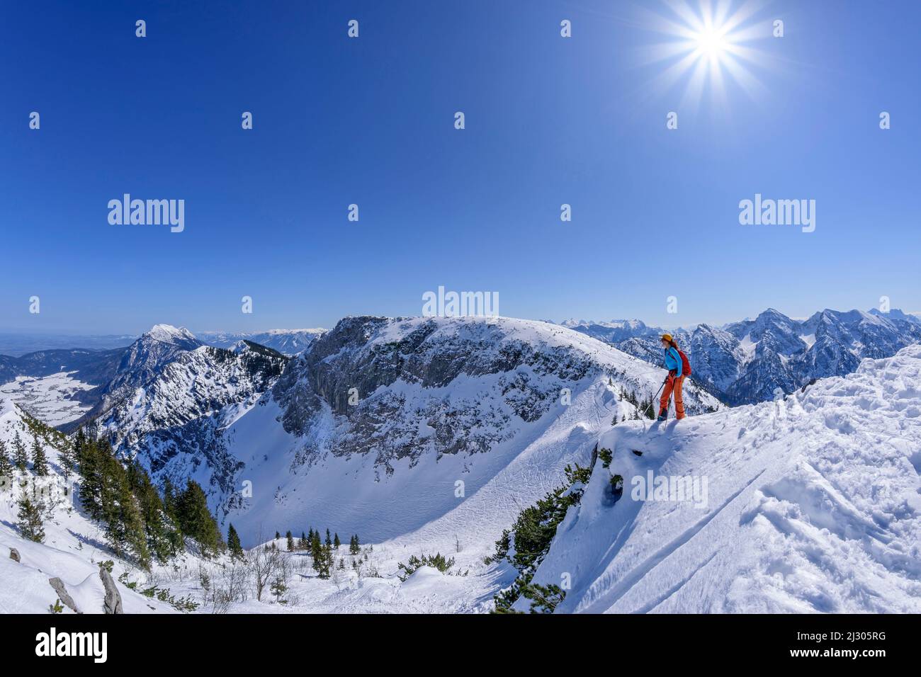 Donna in giro per lo sci si erge sul crinale del Rauschberg e guarda verso il basso, Rauschberg, Alpi del Chiemgau, alta Baviera, Baviera, Germania Foto Stock