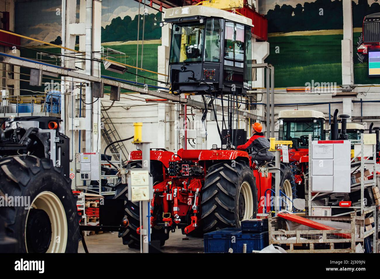 I lavoratori industriali assemblano il trattore agricolo in officina Foto Stock
