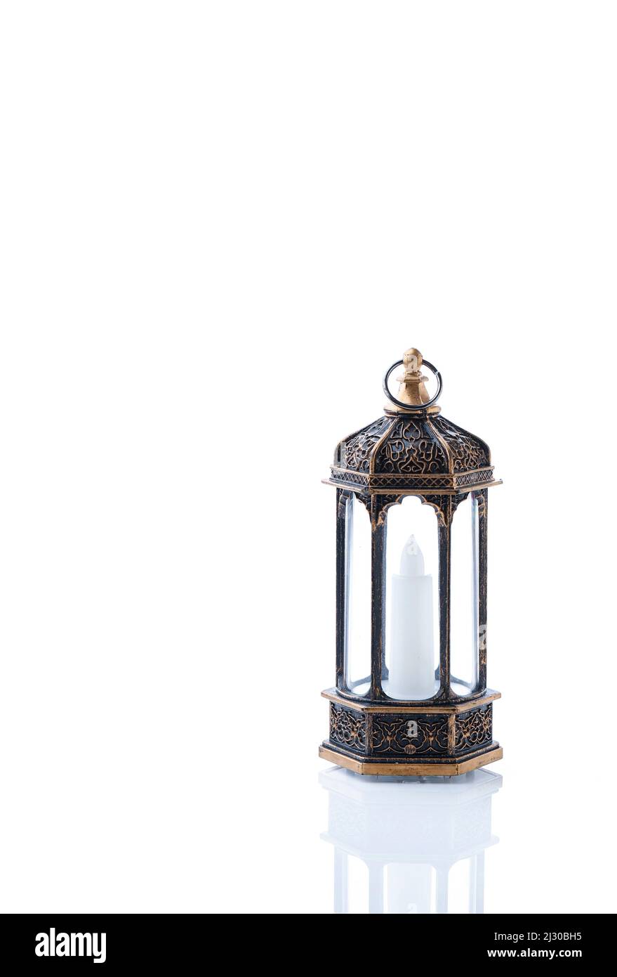 Lanterna Araba ornamentale con candela che brucia su sfondo bianco. Biglietto di auguri per le feste, invito al mese Santo musulmano Ramadan Kareem. Foto Stock