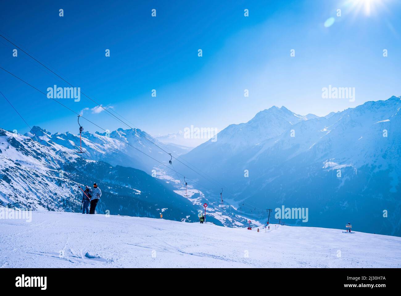 Sciatori a t-bar skilift su neve collina pendio contro il cielo Foto Stock
