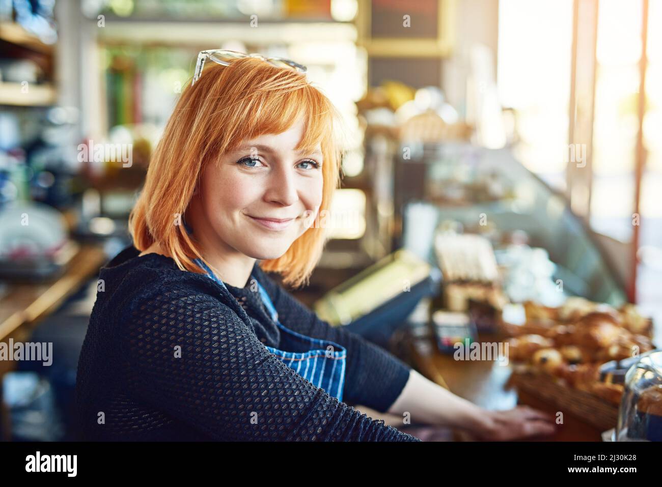 Qui troverete sempre un servizio con un sorriso. Ritratto di una giovane donna fiduciosa che lavora in una caffetteria. Foto Stock