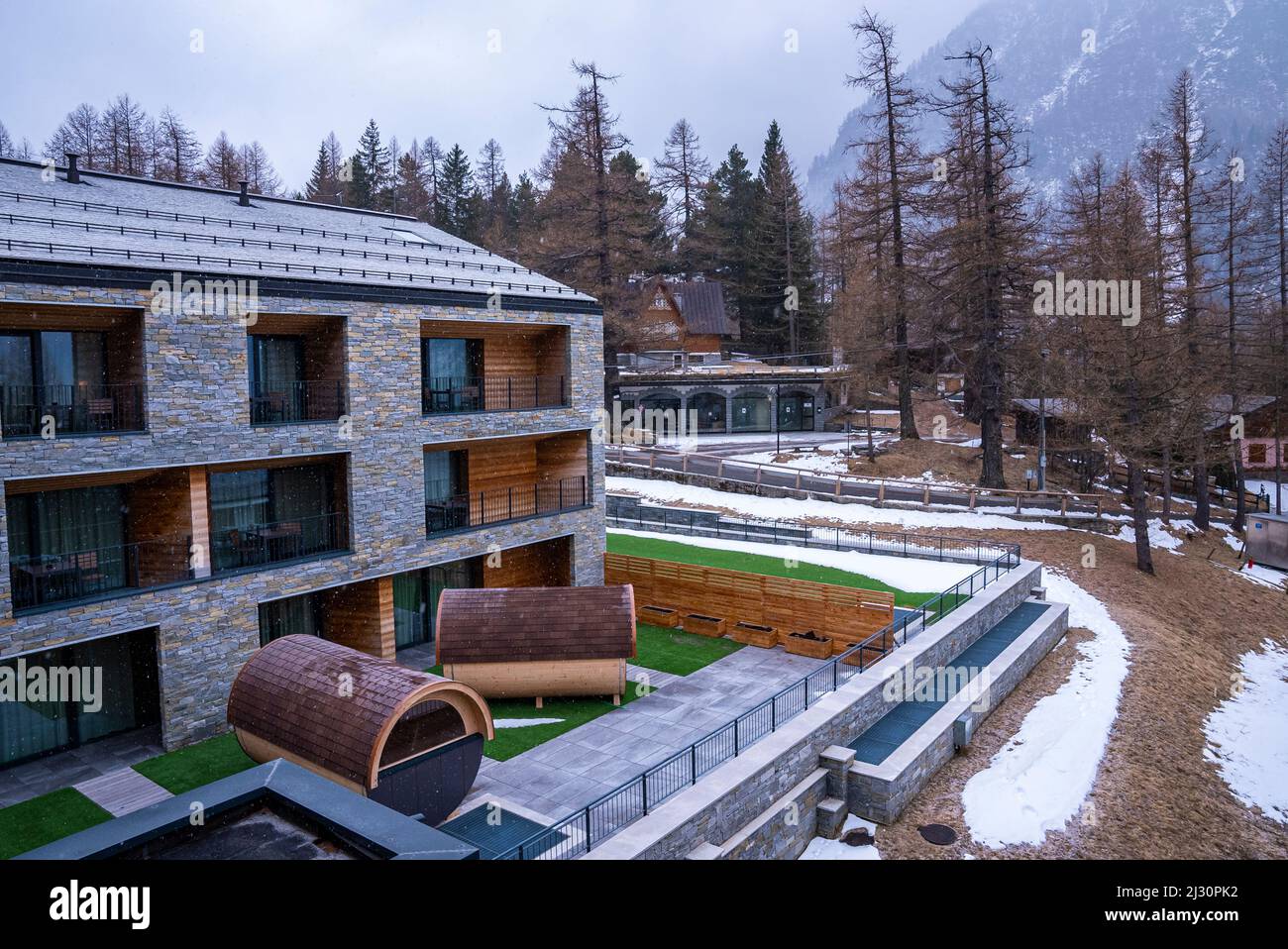 Saune con bagno rotondo all'esterno di un lussuoso edificio alberghiero o resort ad arlberg Foto Stock