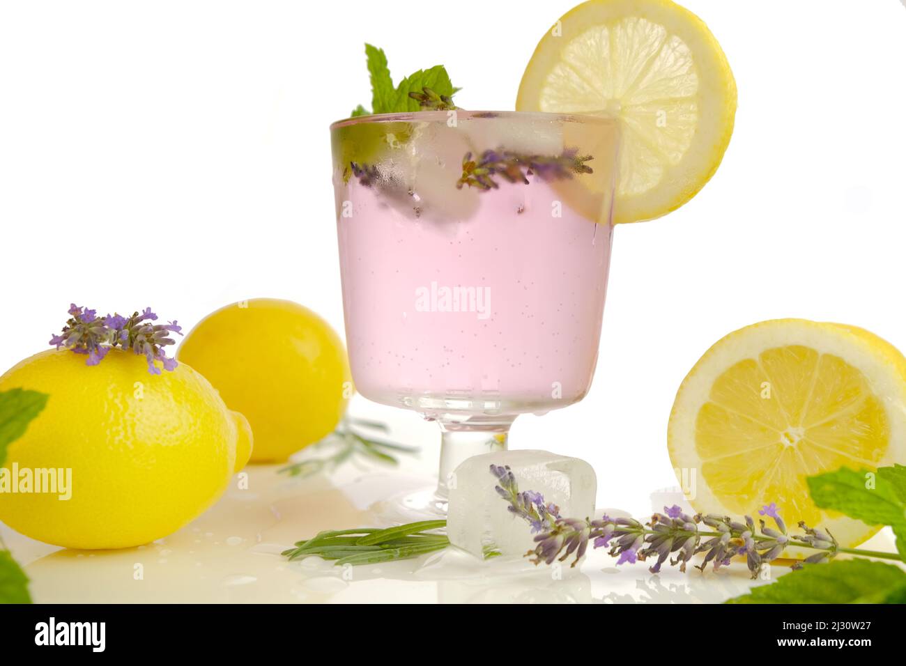 Cocktail di lavanda in un bicchiere da cocktail. Drink estivi. Lavanda limone drink, ghiaccio, limoni e fiori di lavanda. Cocktail rinfrescante Foto Stock