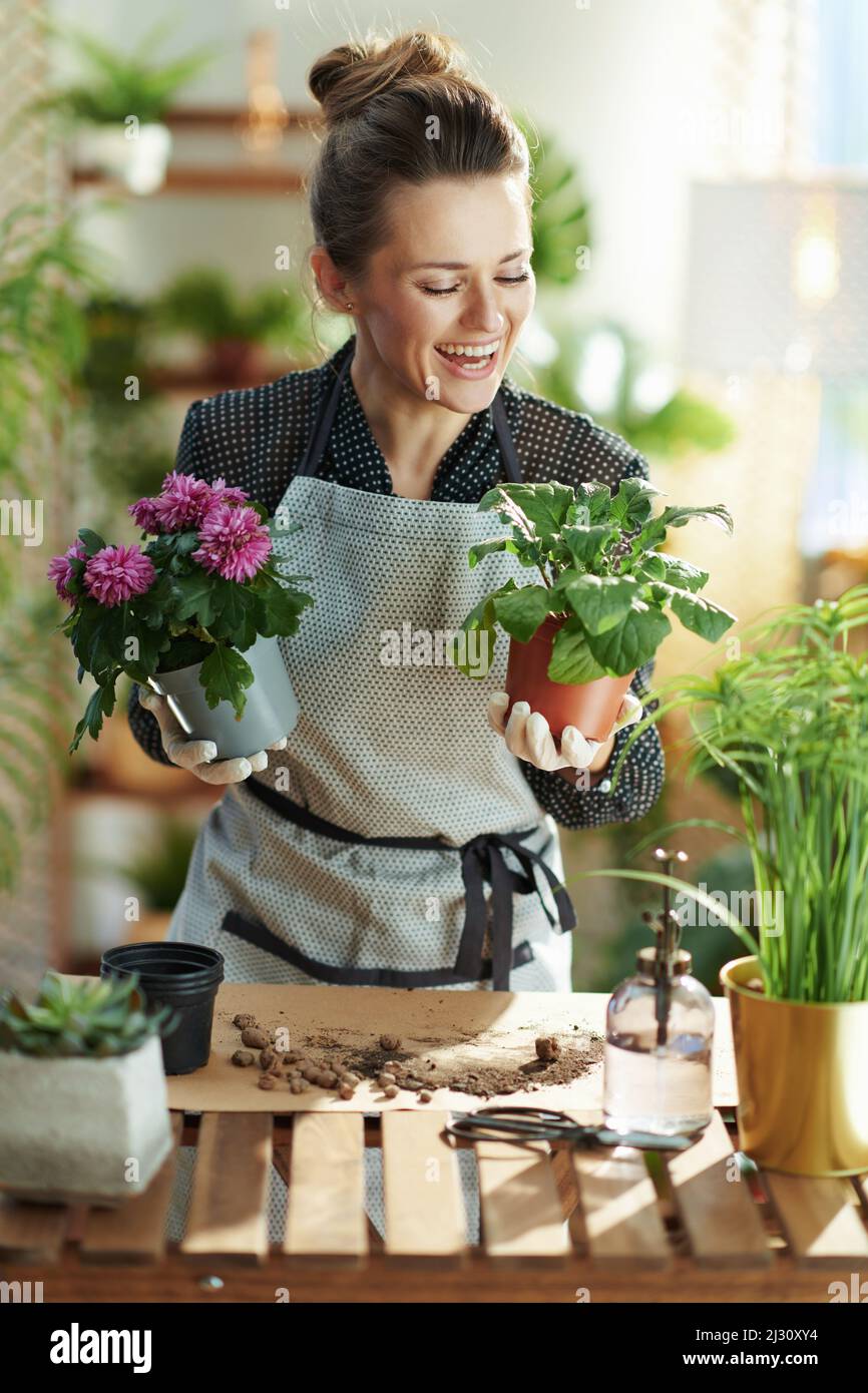 Rilassante giardinaggio casa. Felice femmina moderna in guanti di gomma  bianca con vasi record piante giardinaggio video blog nella casa moderna in giornata  di sole Foto stock - Alamy