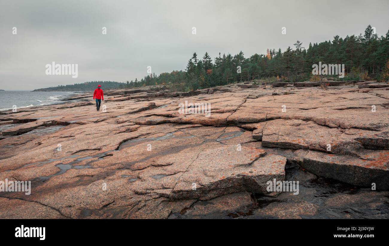 Uomo sulla costa rocciosa di Rottidan nella parte orientale della Svezia Foto Stock
