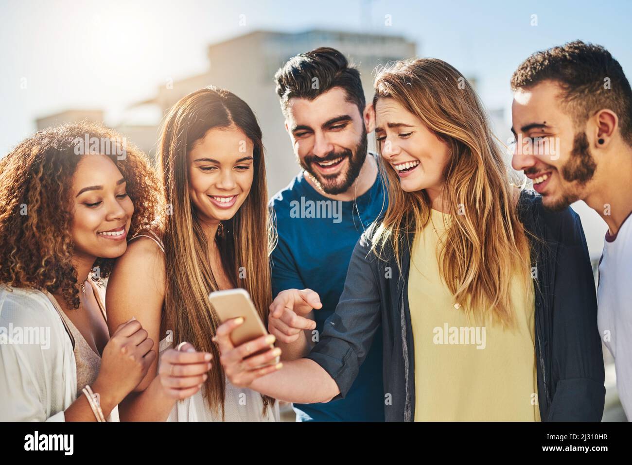 Guardate questa immagine divertente. Scatto di giovani amici con uno smartphone all'aperto. Foto Stock