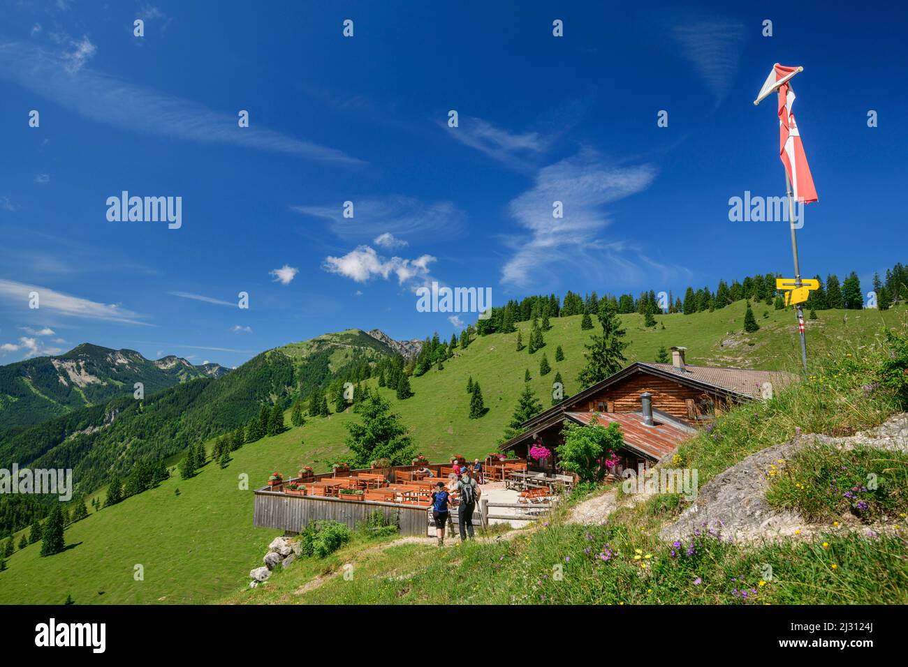 Due persone stand escursionistico di fronte a Alm, Mariandlalm, Trainspoch, Monti Mangfall, Alpi bavaresi, Baviera superiore, Baviera, Germania Foto Stock