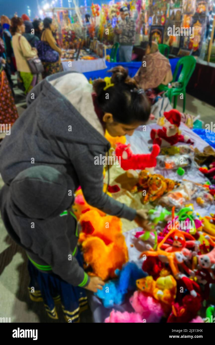 Immagine sfocata di Kolkata, Bengala Occidentale, India. Donna e bambino che acquistano prodotti artigianali all'hastashilpomela o alla fiera dell'artigianato a Kolkata. Foto Stock