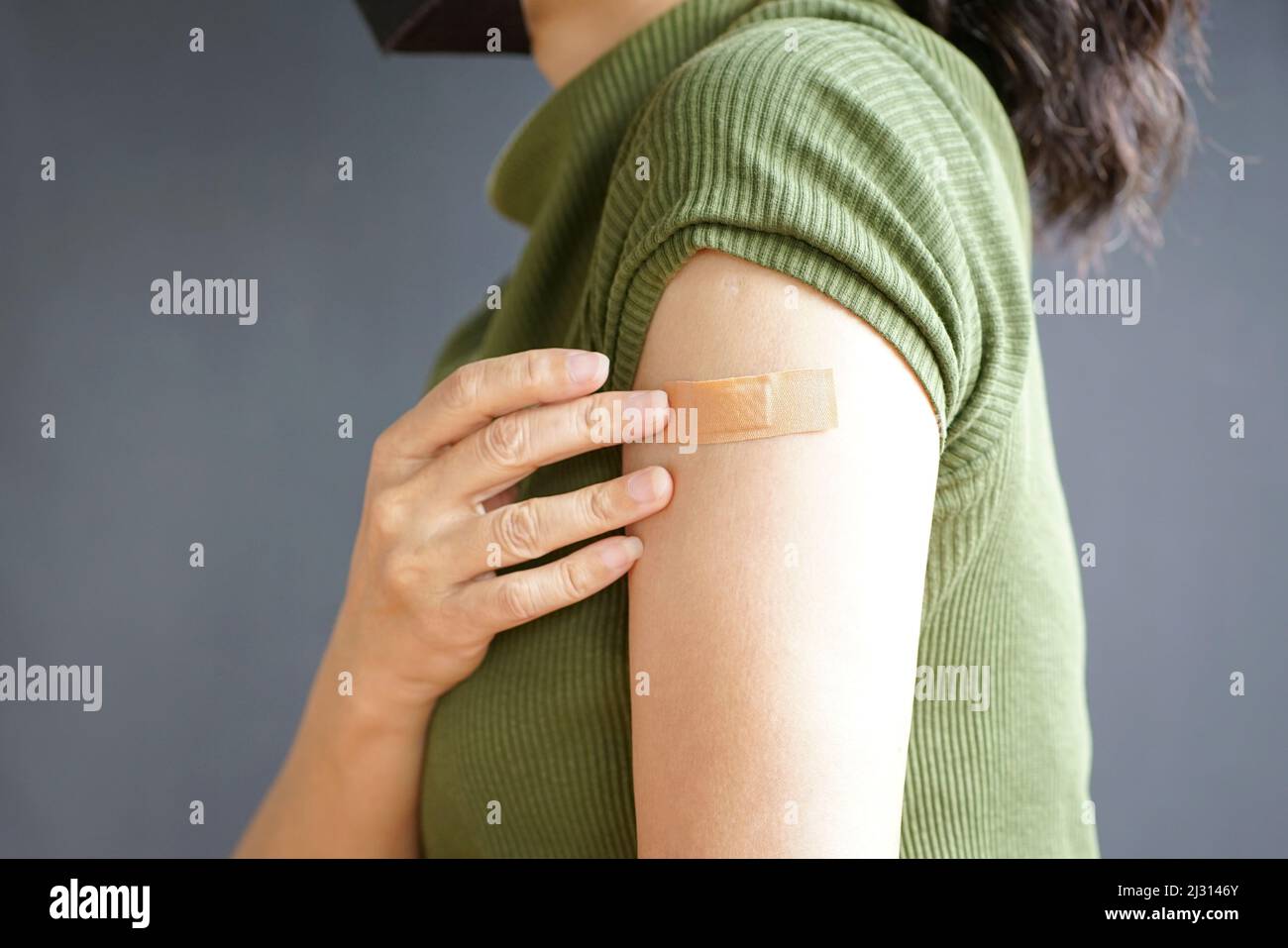 Vista ravvicinata del braccio della donna con bendaggio, immunizzazione vaccinata. Concetto di inoculazione o vaccinazione. Foto Stock