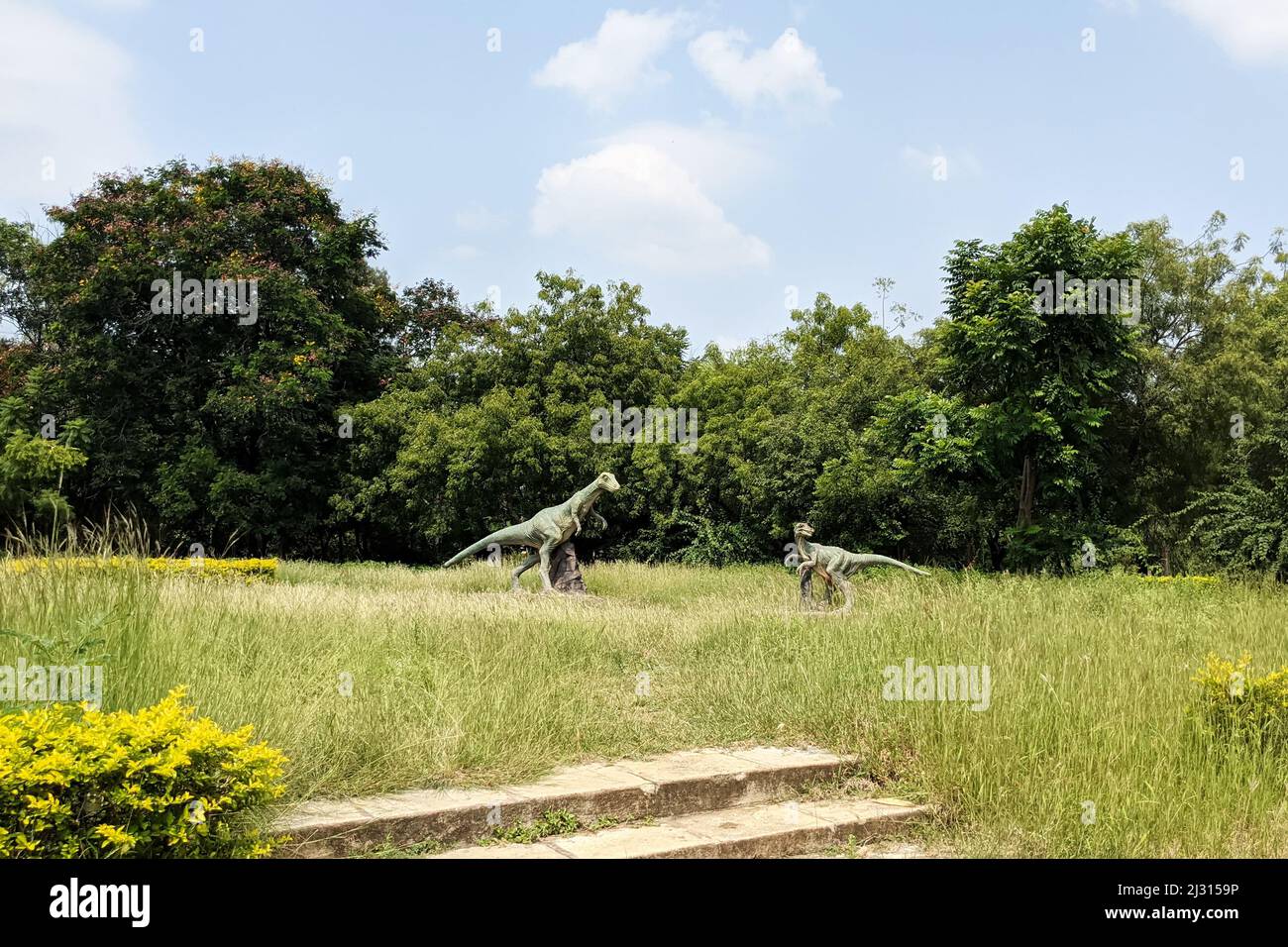 Bel colpo lungo di sculture di cemento di dinosauri isolate nel giardino dell'Università di Gulbarga: Kalaburagi, Karnataka, India-Ottobre 14,2021 Foto Stock