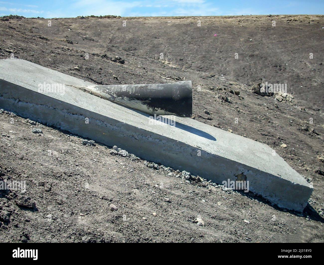 Getto di acqua di scarico tubo di illuminazione diurna dalla laguna di trattamento berma di terra Foto Stock