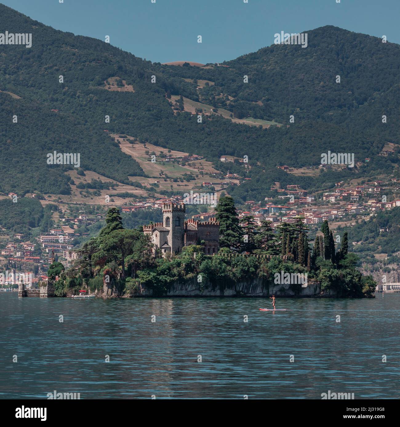 Pagaie donna su SUP di fronte al Castello dell'Isola di Loreto sull'isola del Lago d'Iseo in Italia Foto Stock