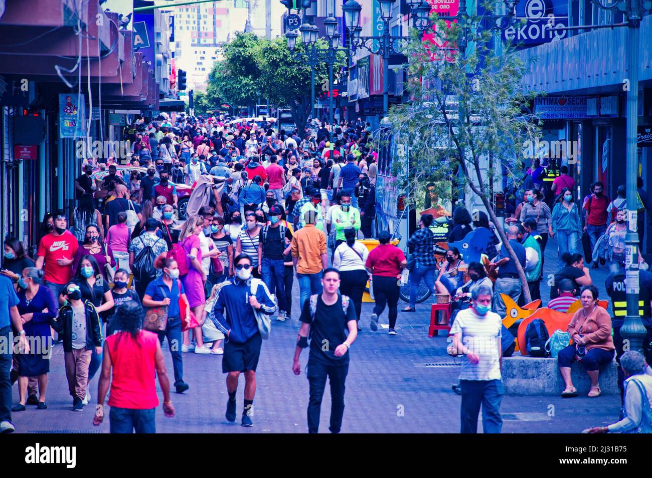 Folla di uomini e donne anonimi che camminano lungo la strada Foto Stock