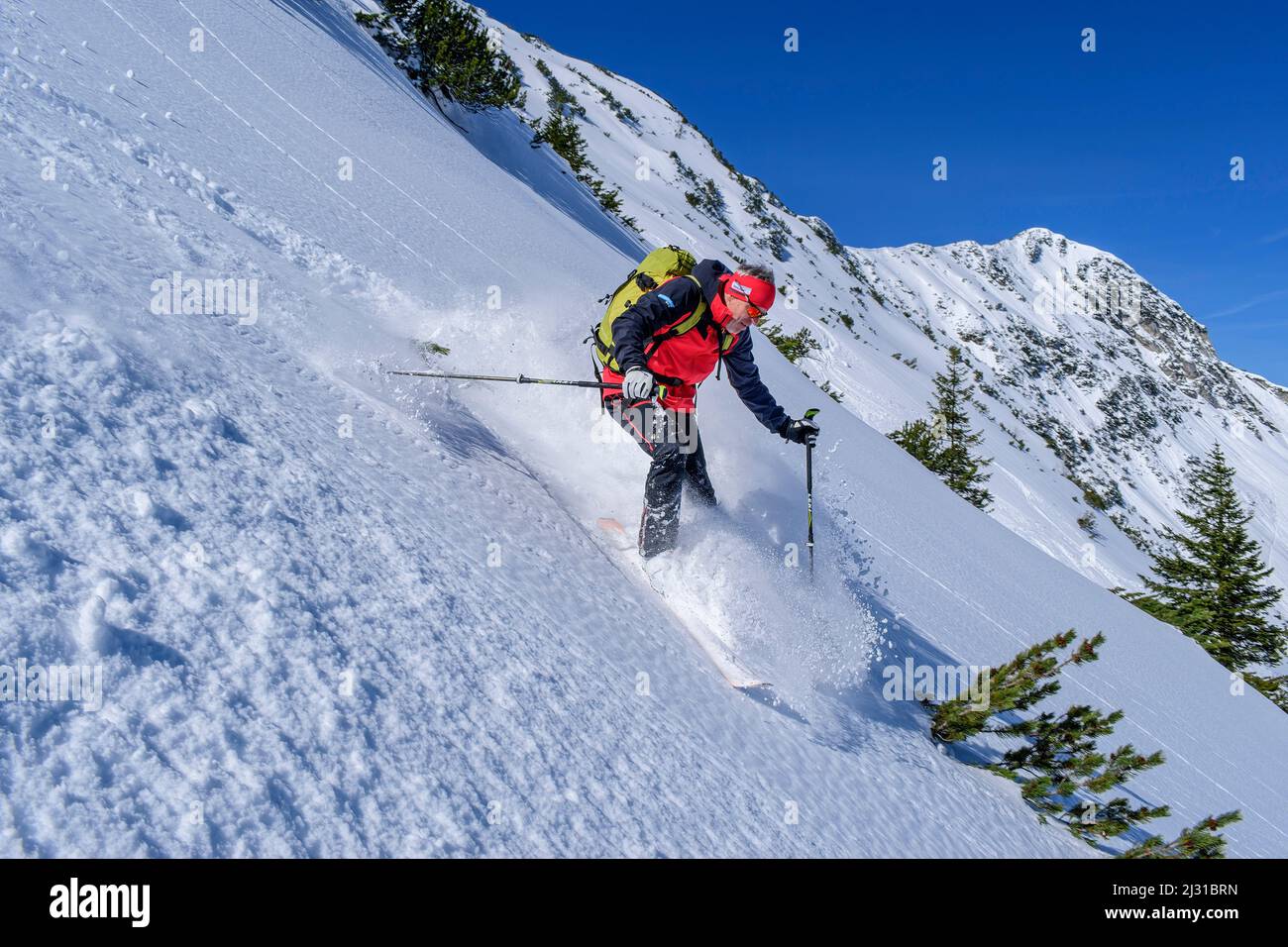 Il tour uomo in sci scende attraverso la pista di neve polverosa, Großer Traithen, le montagne di Mangfall, le Alpi bavaresi, l'alta Baviera, Baviera, Germania Foto Stock