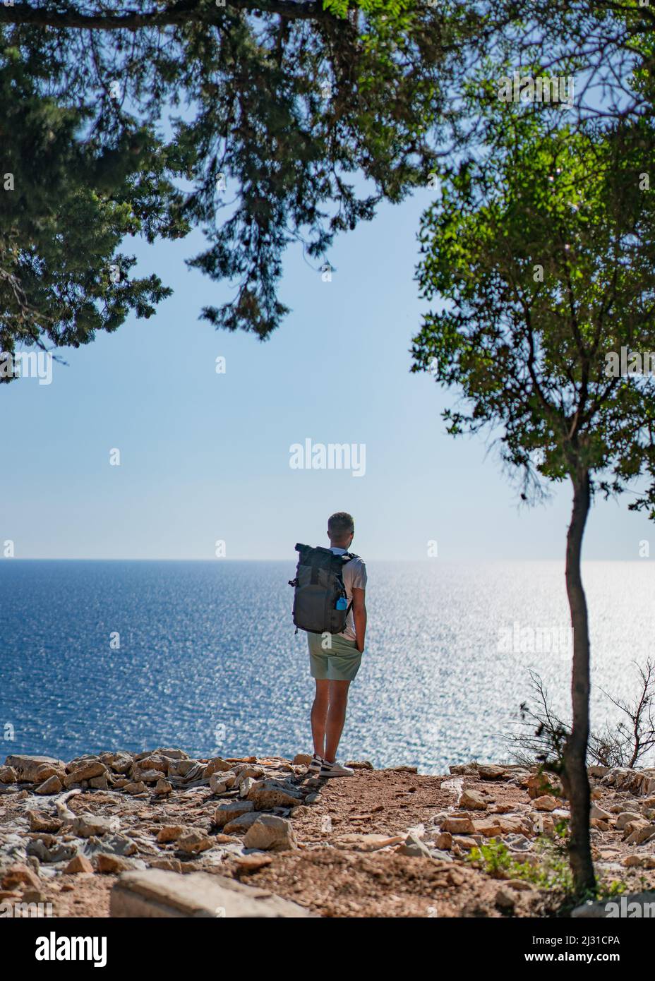 L'uomo guarda fuori dall'isola di Lokrum verso il mare Adriatico di fronte a Dubrovnik, Dalmazia, Croazia. Foto Stock