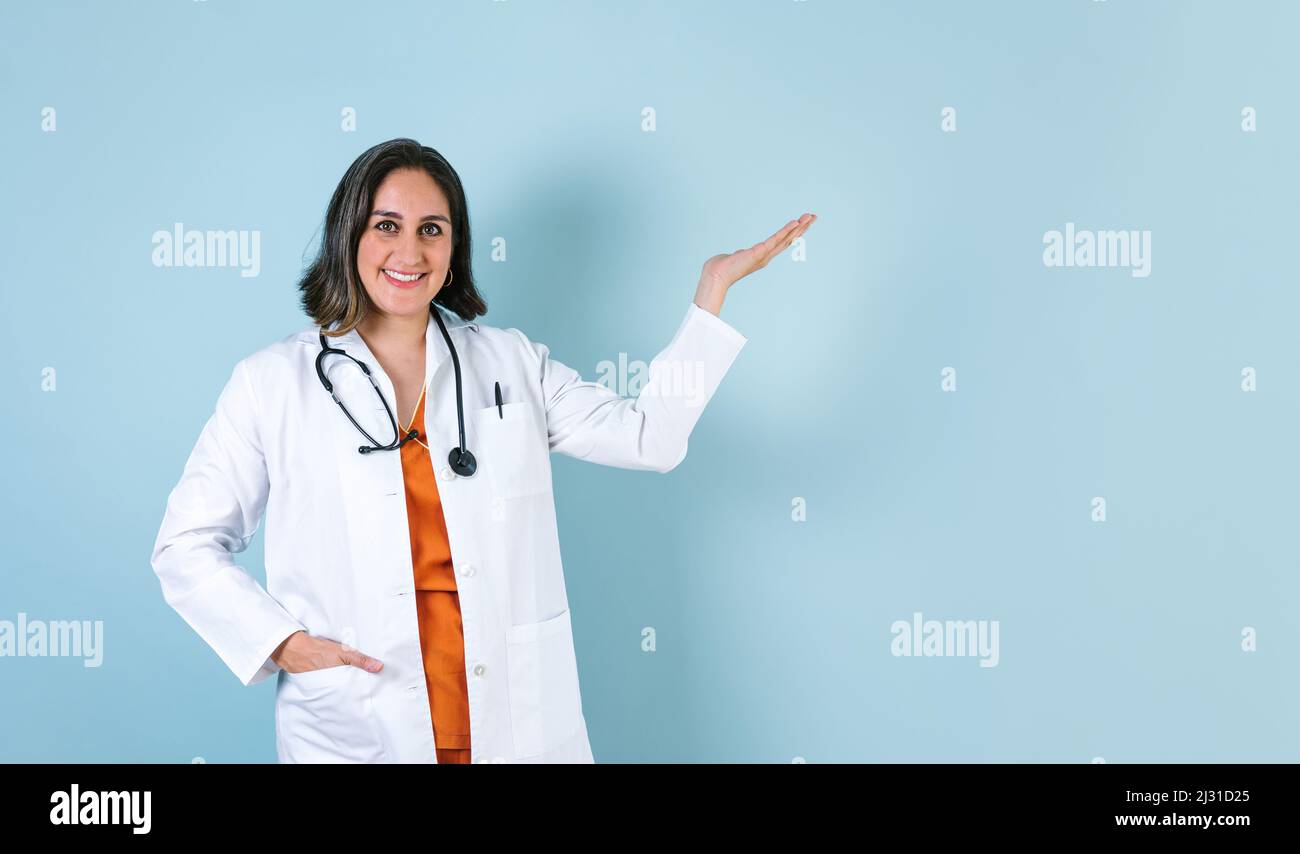 ispanico medico donna ritratto con copia spazio su sfondo blu ridendo in Messico America Latina Foto Stock