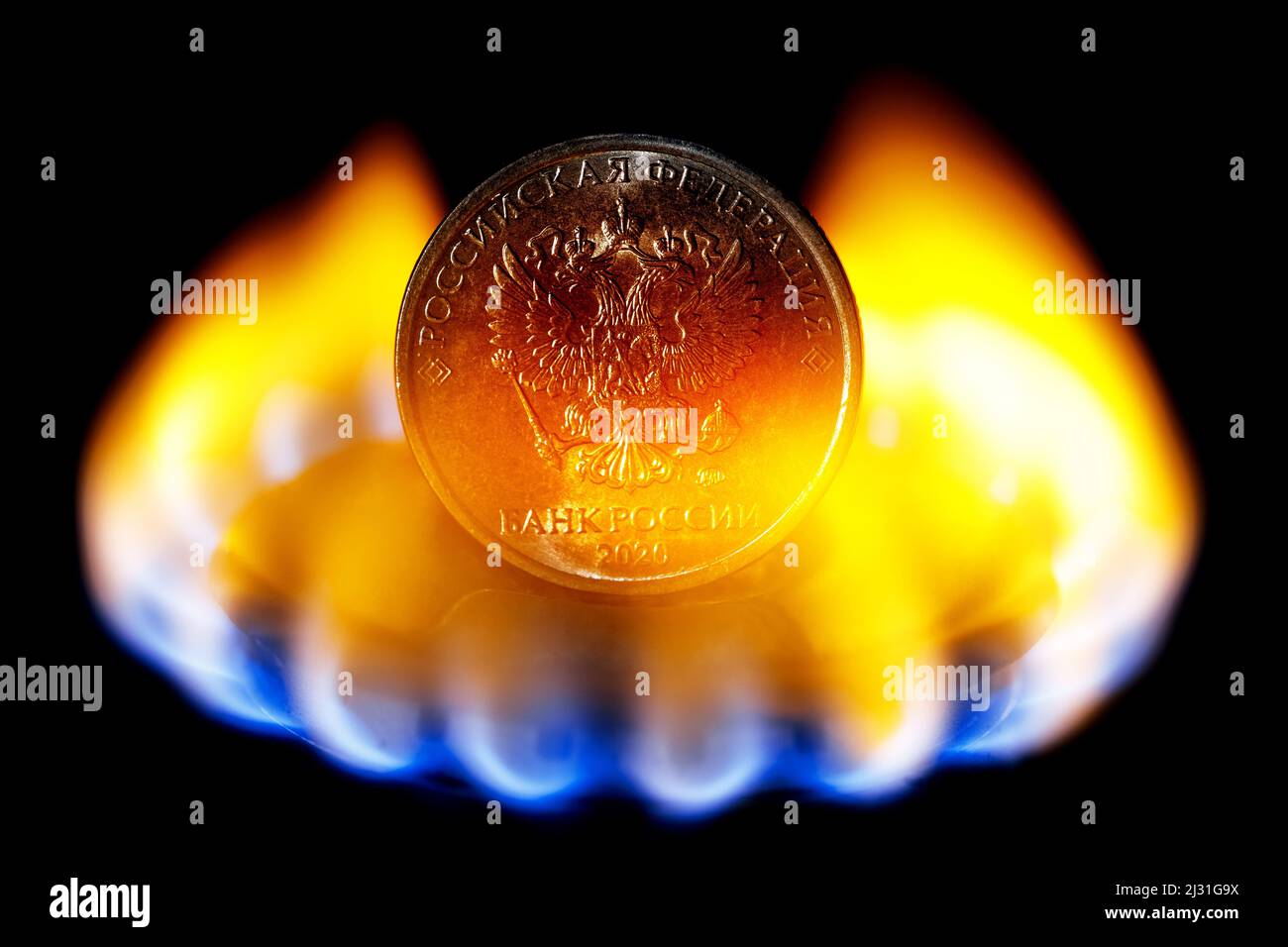 Obverso di moneta rublo con stemma di Russia su bruciatore a gas di stufa da cucina. Il concetto della Russia che vende gas naturale per rubli. Foto Stock
