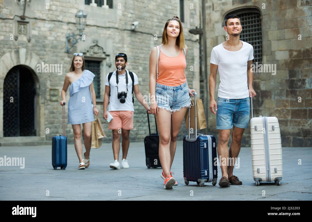 Coppia felice prendendo la passeggiata e trascinando valigie Foto Stock