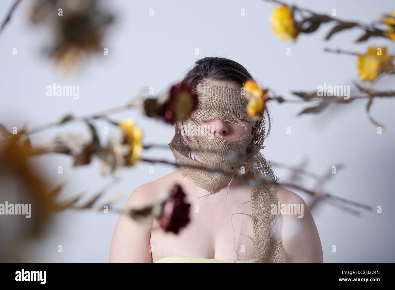 Figura femminile faccia avvolta in tela, simboleggiando la pelle che si sparge e che si trasforma Foto Stock