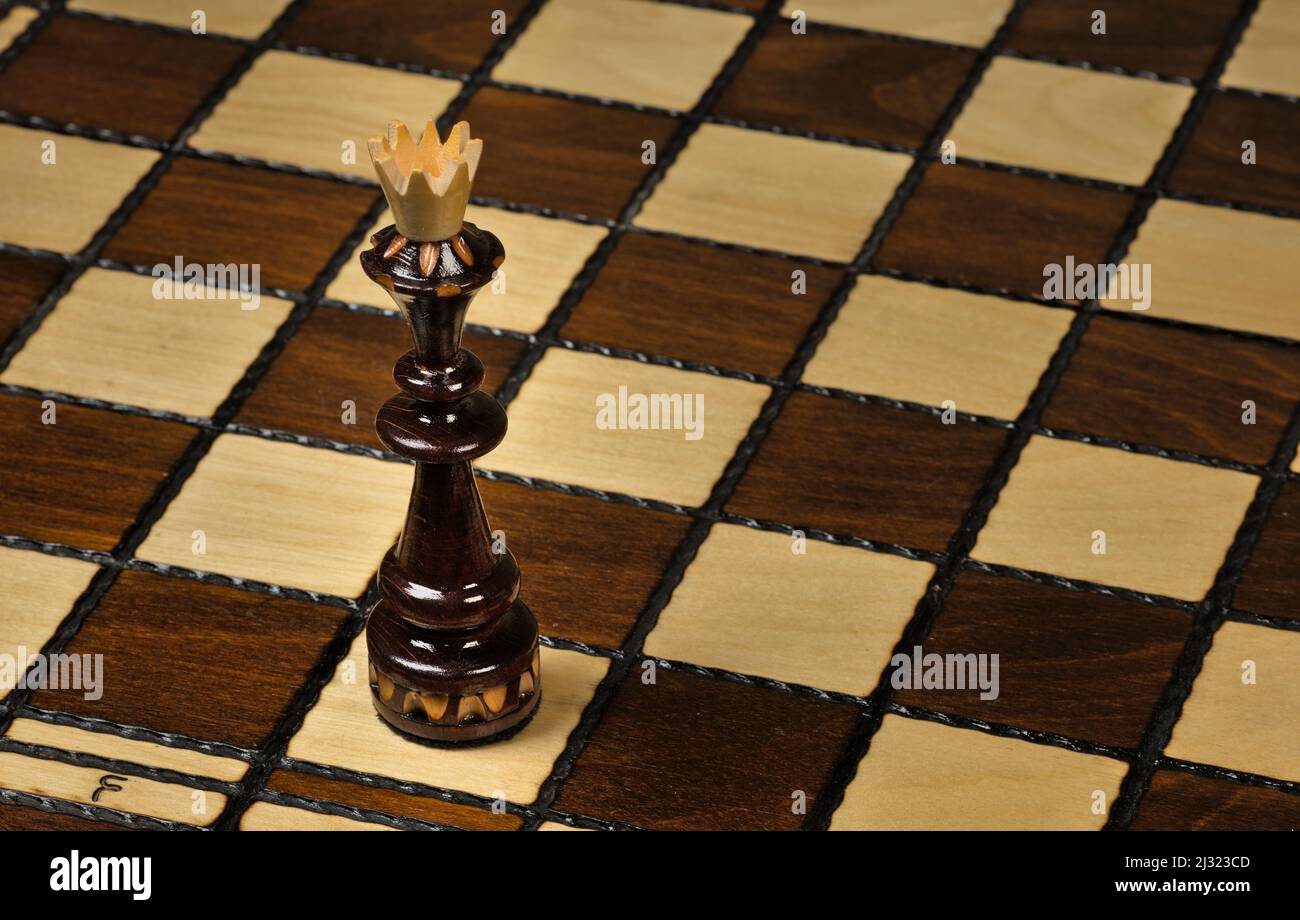 Re nero in piedi su una scacchiera Foto Stock