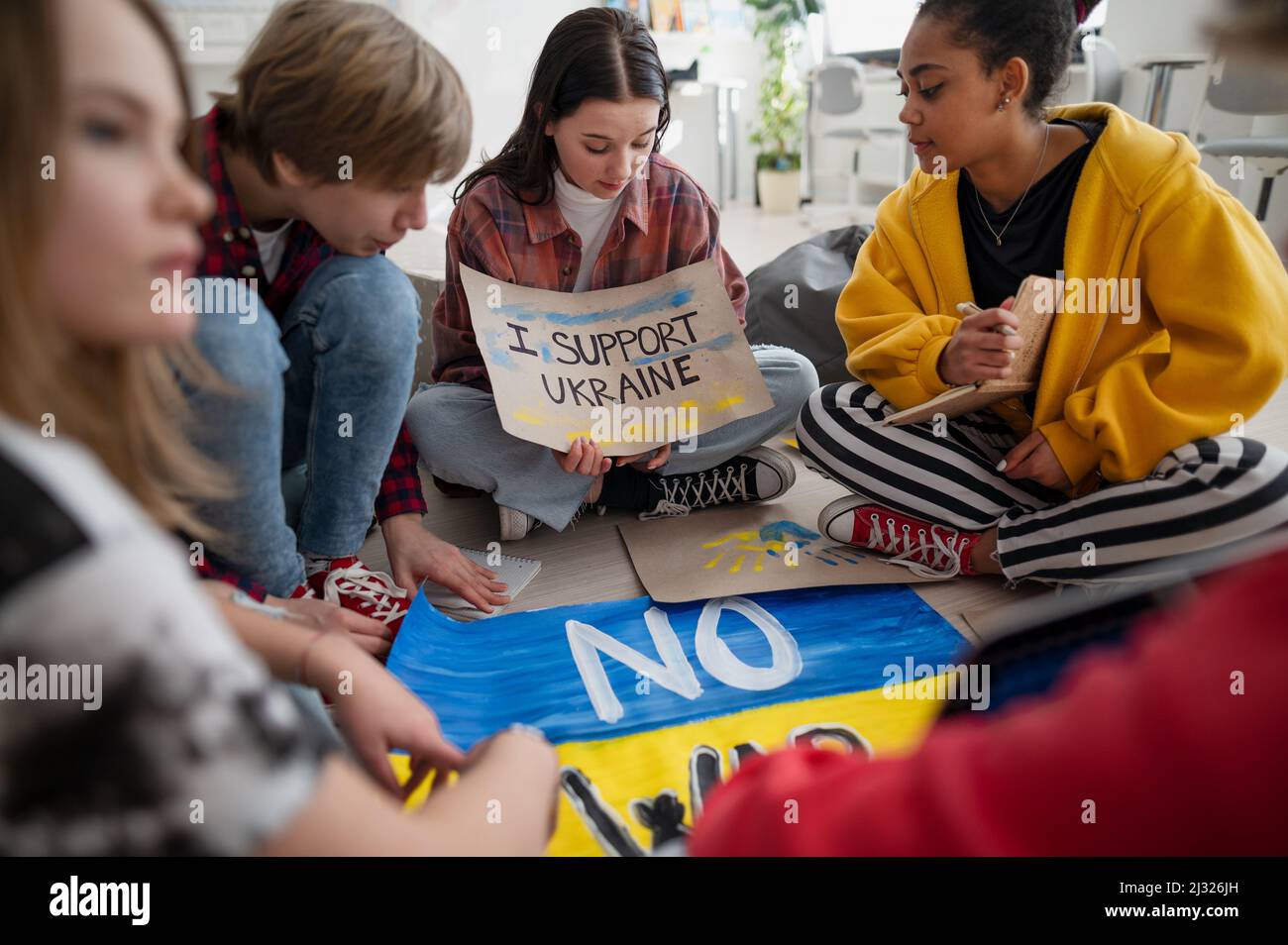 Studenti adolescenti seduti a cerchio in classe con poster a supporto dell'Ucraina, nessun concetto di guerra. Foto Stock