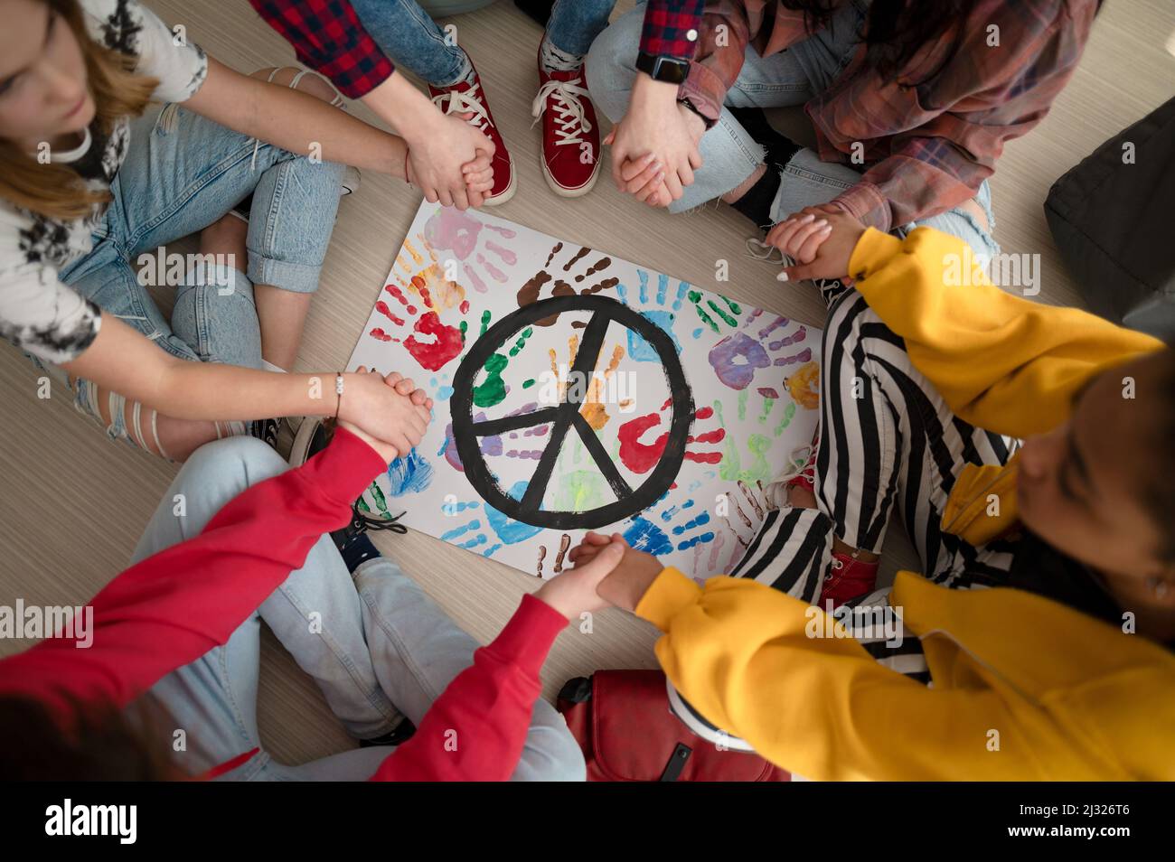 Vista dall'alto degli studenti che pregano per la pace nel mondo a scuola. Foto Stock