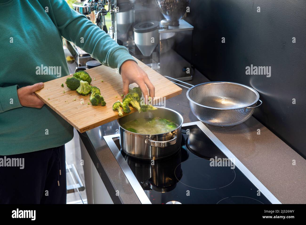 Broccoli vegetali bollenti su un piano di cottura a induzione. Foto Stock