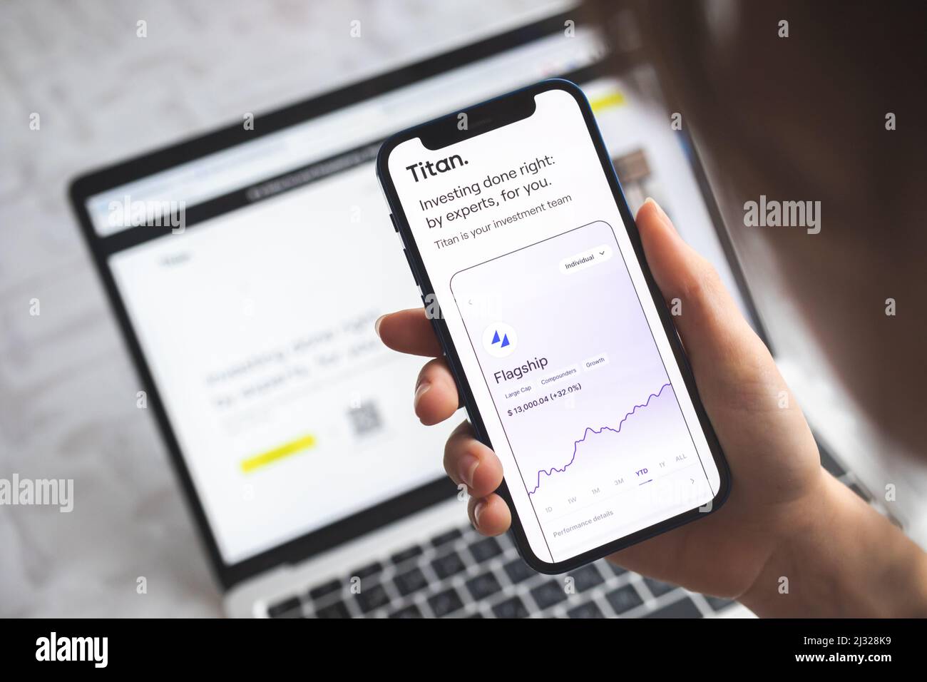 Poltava, Ucraina - 5 aprile 2022: La donna usa Titan INVEST app. Mobile phone banking e concetto di investimento foto Foto Stock