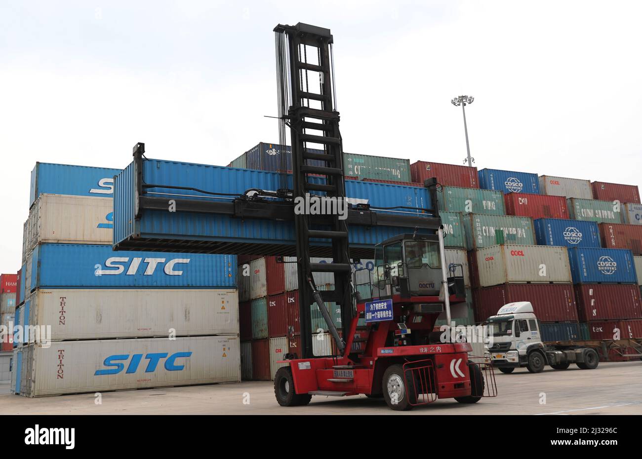 QINGDAO, CINA - 5 APRILE 2022 - un carrello elevatore a forche è visto impilare contenitori il 5 aprile 2022. Nel primo trimestre del 2022, il volume di carico di Foto Stock