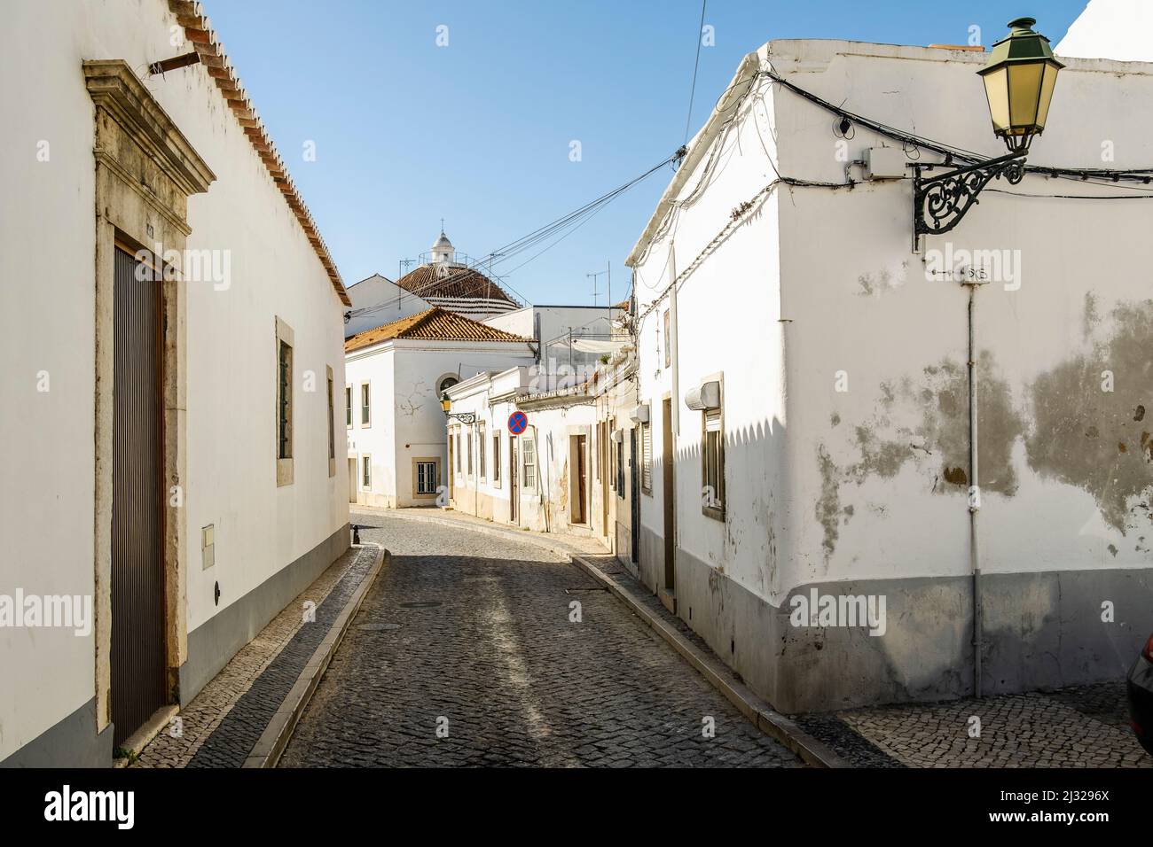 Strada stretta con edifici imbiancati nel centro di Faro, Algarve, Portogallo Foto Stock