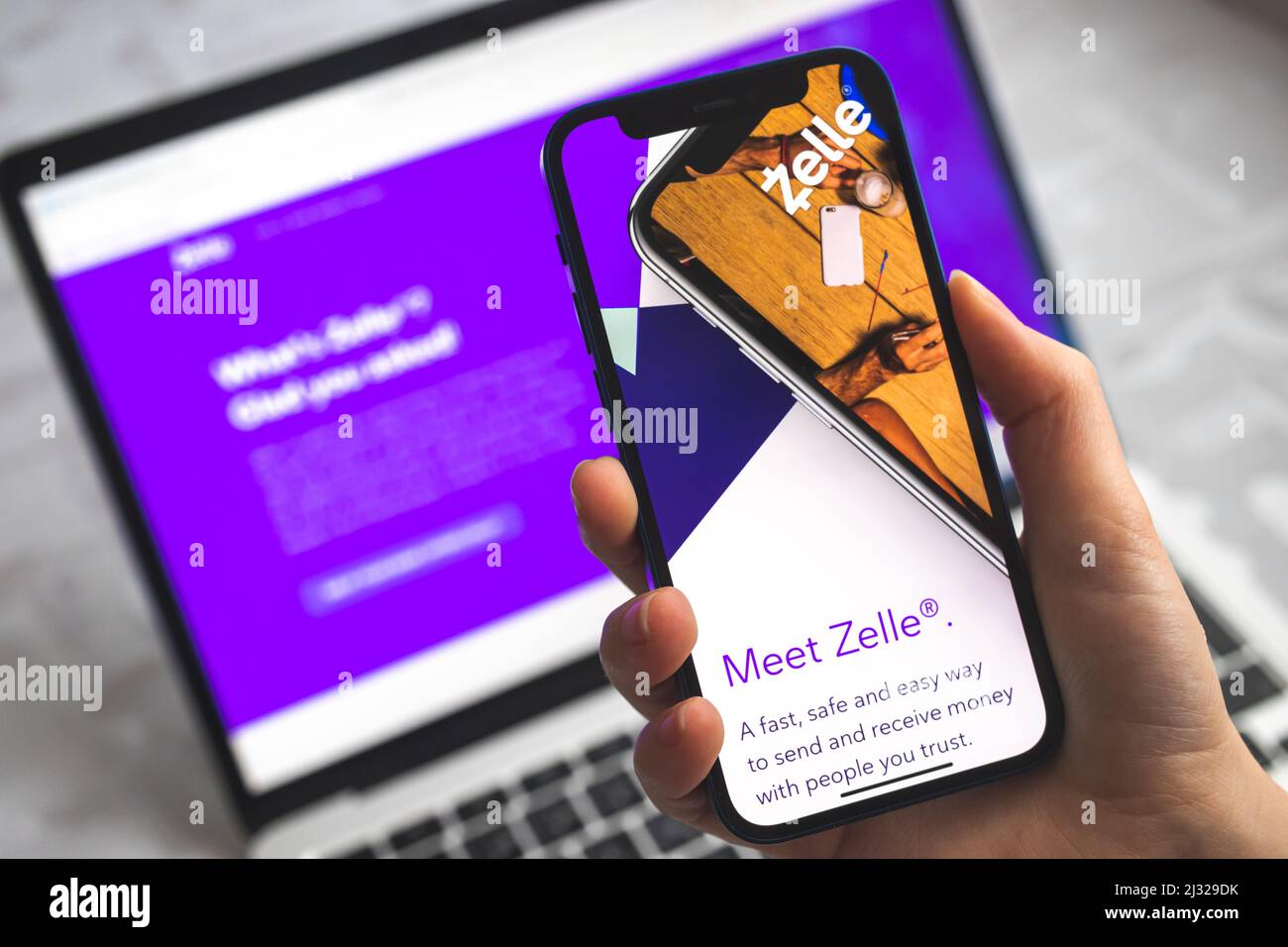 Poltava, Ucraina - 5 aprile 2022: Donna usa Zelle app. Mobile phone banking e concetto di investimento Foto Stock