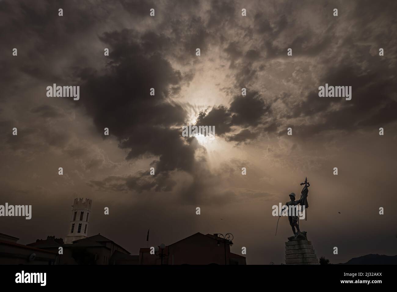 La Statua del Memoriale di Guerra sulla destra e il tour della Chiesa di Saint Dominique sulla sinistra di questo fotograp al tramonto Foto Stock