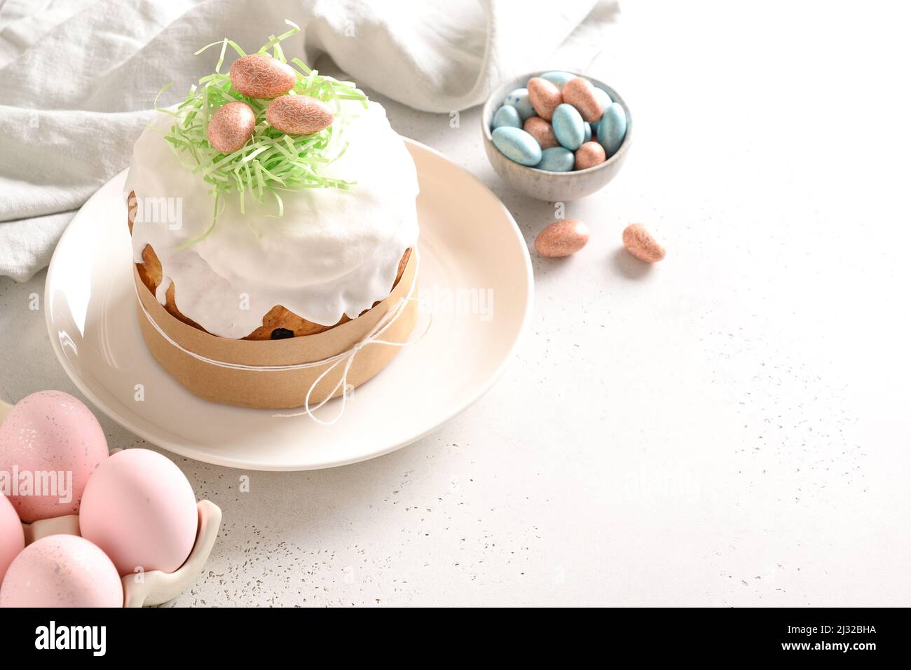 Torta di Pasqua e uova rosa colorate su sfondo bianco. Spazio per il testo. Foto Stock