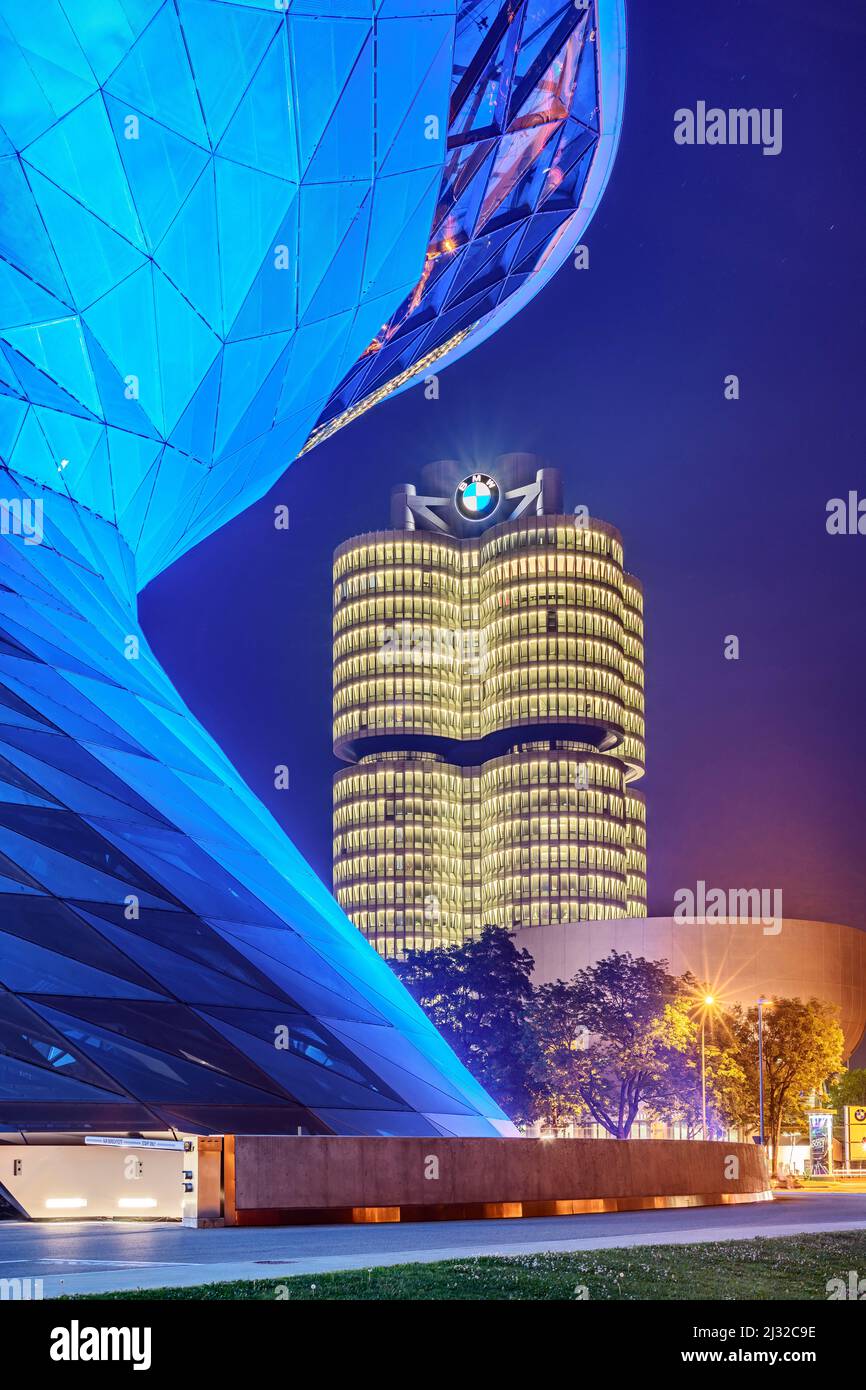 Edificio blu illuminato BMW Welt con quattro cilindri BMW e Museo BMW sullo sfondo, Monaco, alta Baviera, Baviera, Germania Foto Stock
