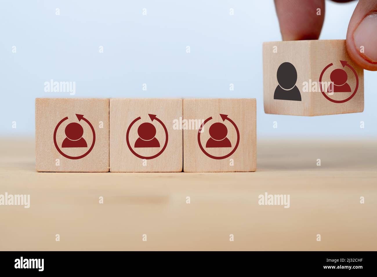 Concetto di riqualificazione per la formazione dei dipendenti su un set di competenze completamente nuovo per la crescita aziendale e la trasformazione digitale. L'uomo capovolge il cubo di legno con il genero Foto Stock