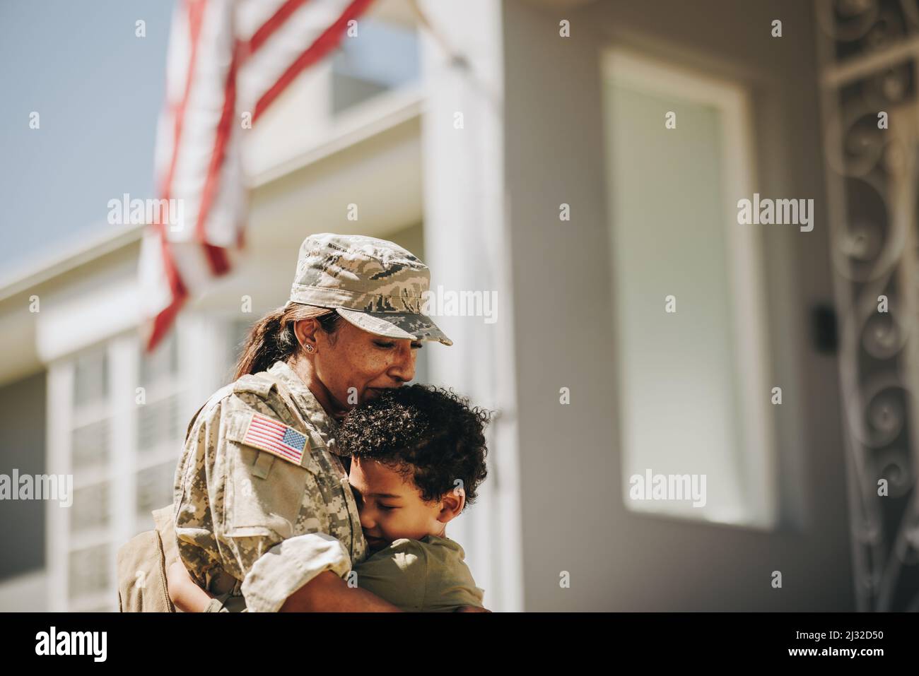Madre e figlio si riuniscono dopo lo spiegamento militare. Mamma emozionale che abbraccia suo figlio dopo essere tornato a casa dall'esercito. Donna patriottica soldato recei Foto Stock